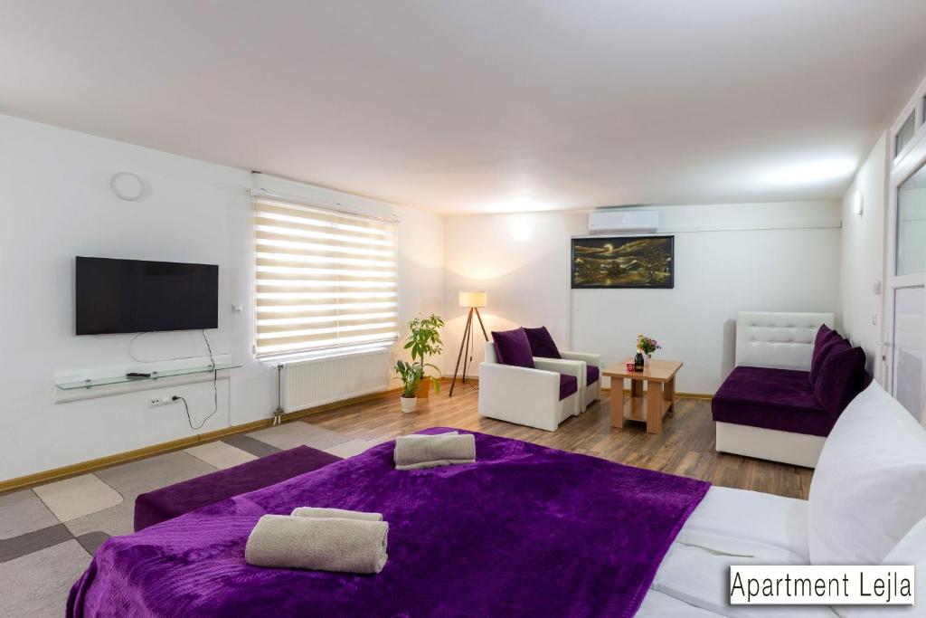a living room with a purple bed and a tv at Pansion Beg in Tuzla
