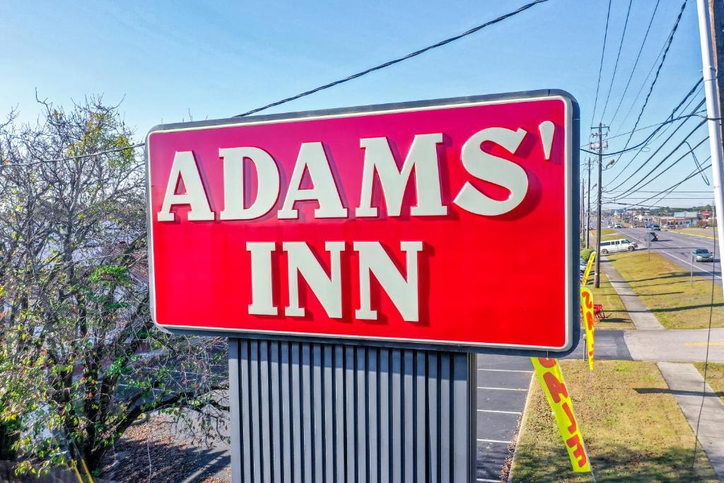 un cartello rosso che legge adamiants inn di Adams Inn a Dothan