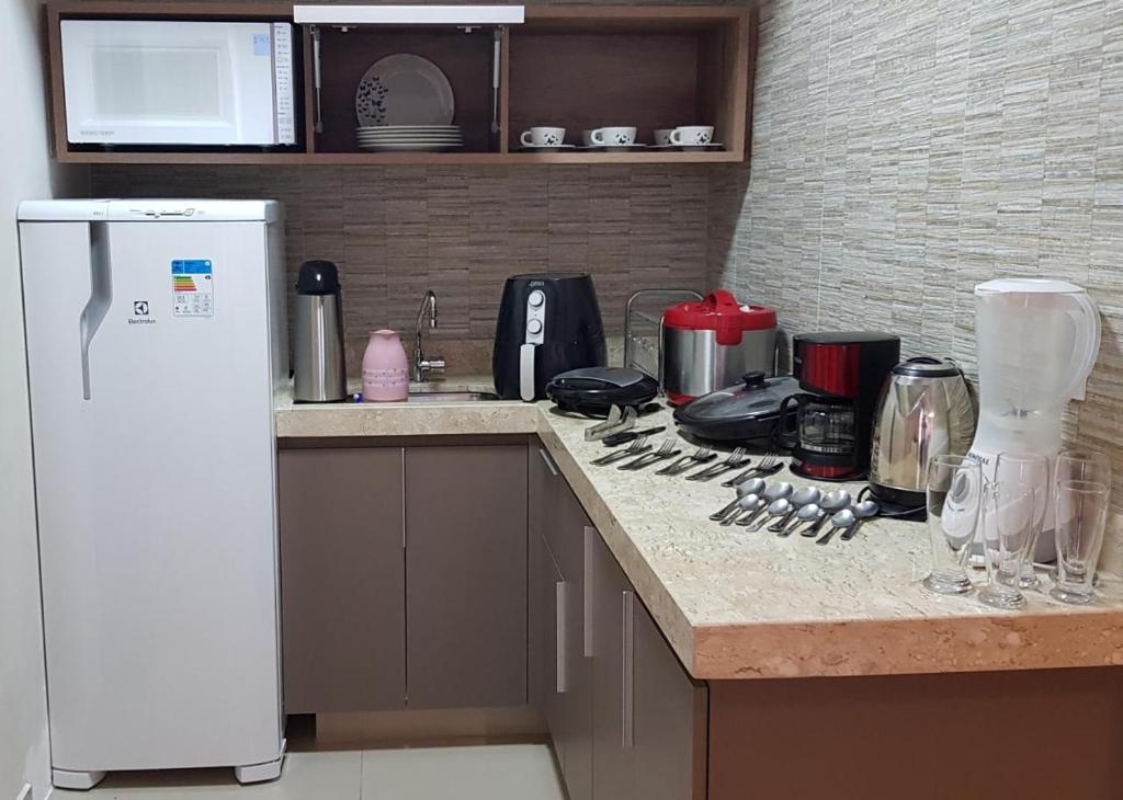 a kitchen with a counter top with a white refrigerator at Park Veredas, Flat 407 - Rio Quente - GO in Rio Quente