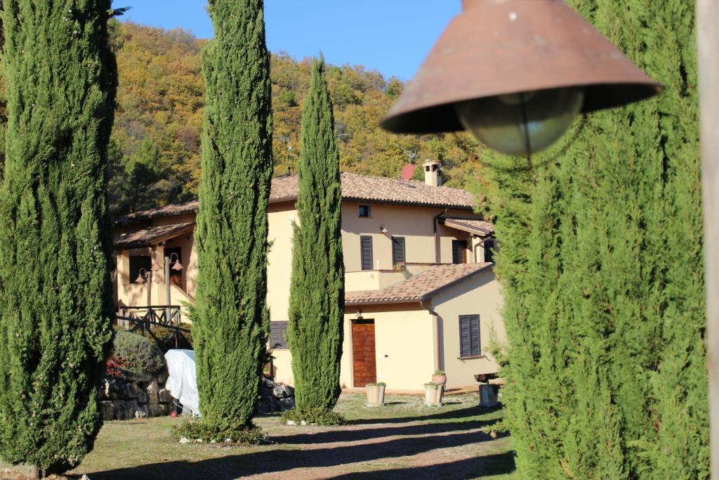 um conjunto de ciprestes em frente a uma casa em Il Borgo delle Stelle em Colle del Marchese