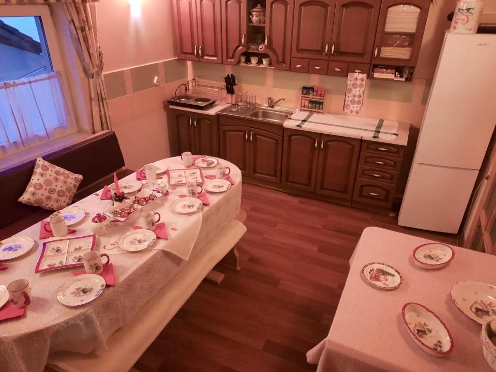 eine Küche mit zwei Tischen und rosa Geschirr drauf in der Unterkunft Antal Villa - 5mins to ski slope & 1min to skating in Harghita-Băi