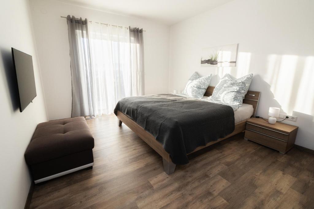 a bedroom with a bed and a chair in it at Ferienwohnung Bergäcker in Neualbenreuth