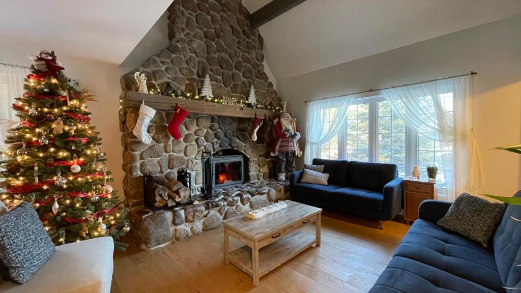 a living room with a christmas tree and a fireplace at Le Pimbina in Mont-Tremblant