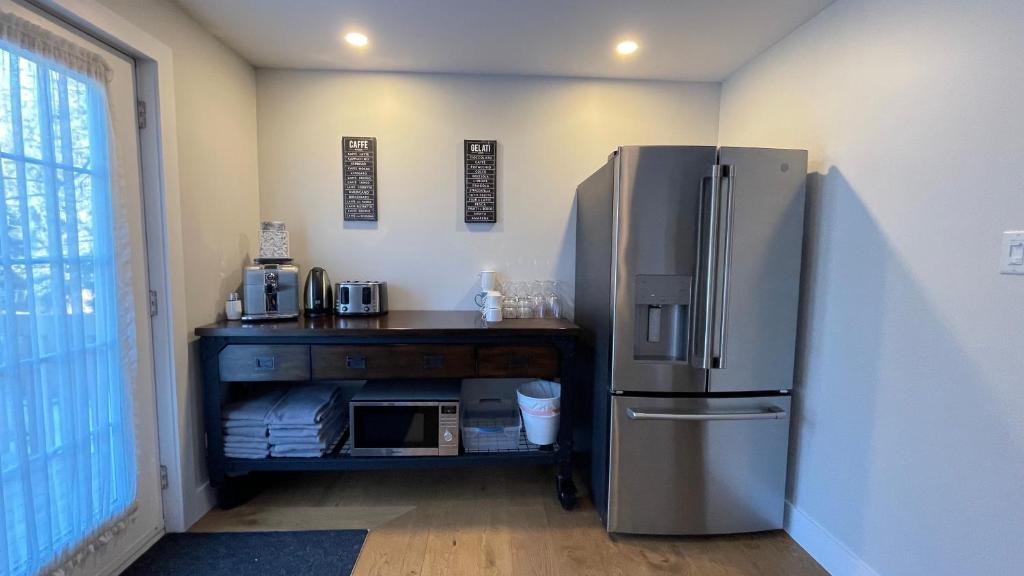 a kitchen with a refrigerator and a table with a microwave at Le Pimbina in Mont-Tremblant