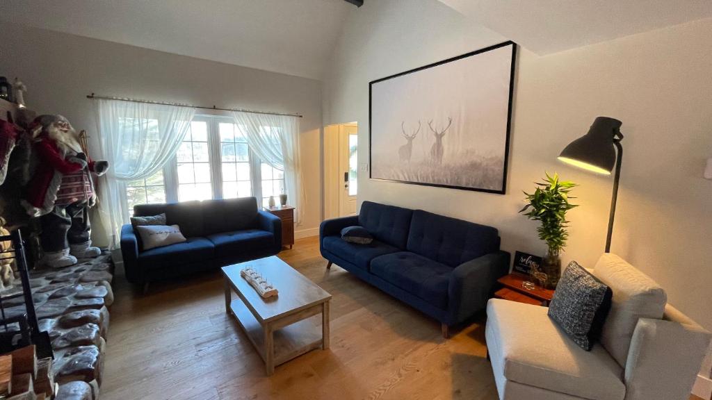 a living room with two blue couches and a table at Le Pimbina in Mont-Tremblant