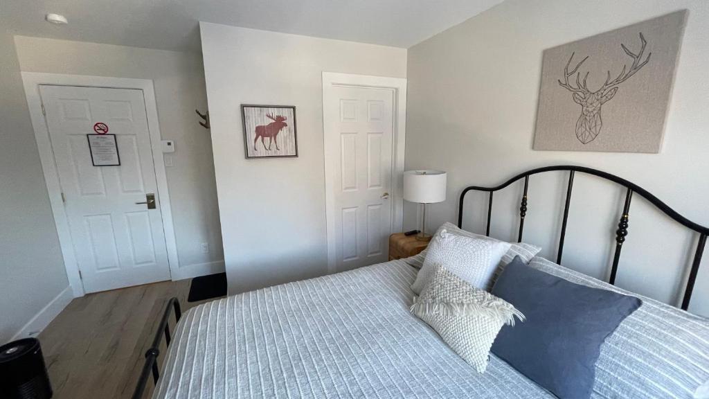 a bedroom with a bed and two white doors at Le Pimbina in Mont-Tremblant