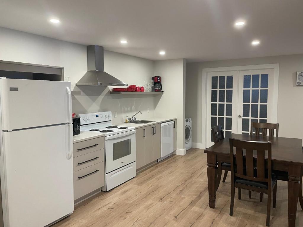 a kitchen with a white refrigerator and a table at Le Pimbina in Mont-Tremblant