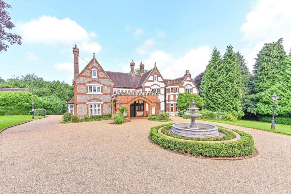 ein großes Haus mit einem Brunnen in der Einfahrt in der Unterkunft Exquisite Manor House in Surrey Hills in Lower Kingswood