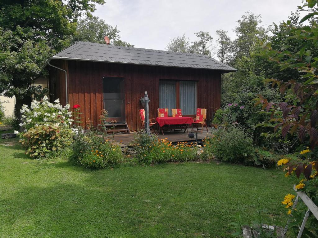 Cabaña pequeña con mesa y sillas en un patio en Ferienhaus Triebesgrund en Zeulenroda