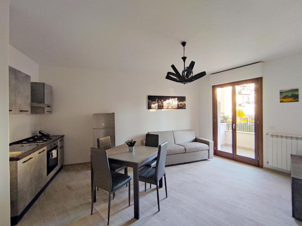 a kitchen and living room with a table and a couch at Silver Apartment in Arezzo