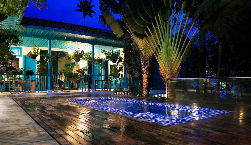 a swimming pool in the middle of a courtyard at night at Casa de las Dos Palmas in Salento