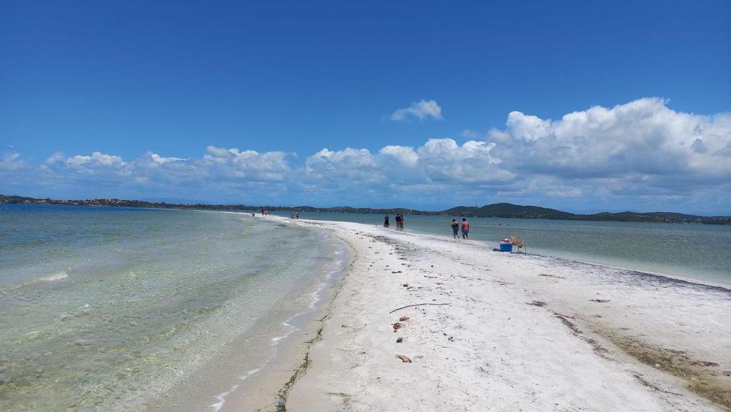 um grupo de pessoas caminhando na praia em Casa Arraial do Cabo - Figueira em Arraial do Cabo