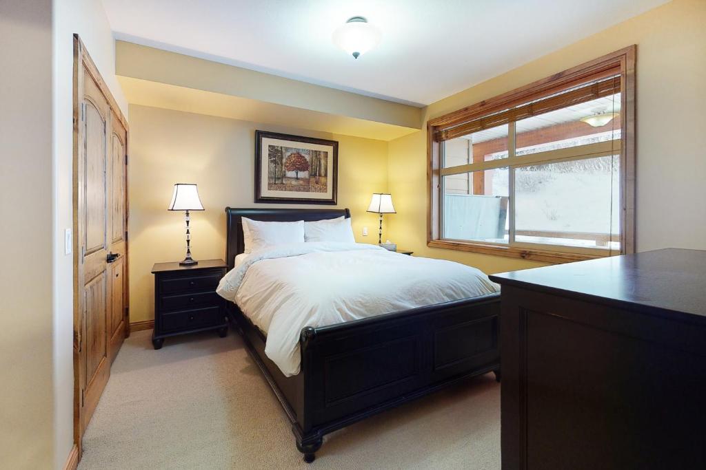 a bedroom with a large bed and a window at Aspens 4406 in Big White