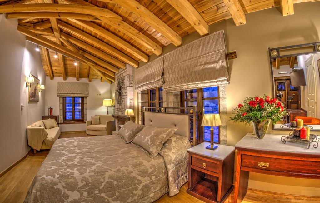 ein Schlafzimmer mit einem Bett und einem Sofa in einem Zimmer in der Unterkunft Archontiko Deligianni in Dimitsana