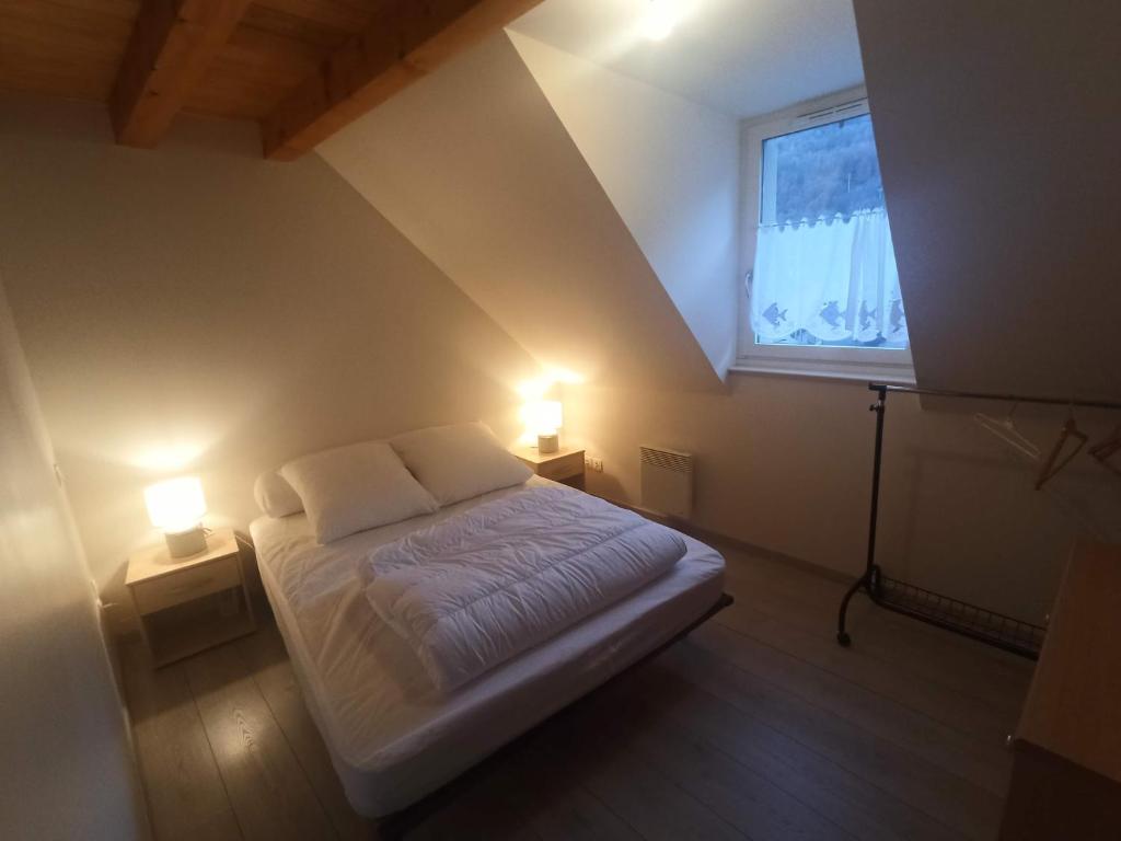 a small bedroom with a bed and two lamps at Le Therminus, T2Bis au cœur de Luchon in Luchon