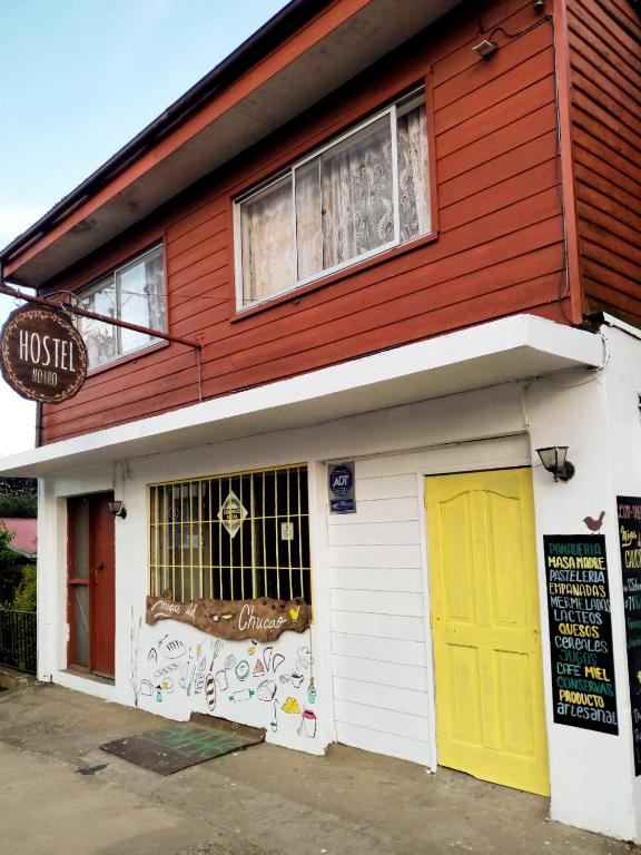 a red and white building with a yellow door at Hostel Notro Valdivia in Valdivia