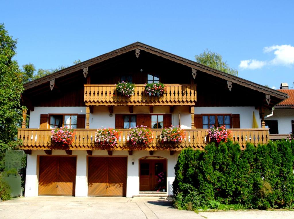 une maison dotée d'un balcon avec des boîtes de fleurs. dans l'établissement Beim Bretzner - Chiemgau Karte, à Inzell