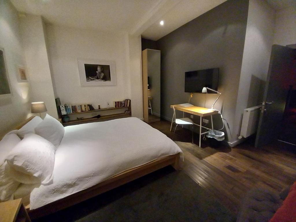 a bedroom with a large white bed and a desk at cool room in shared house in York