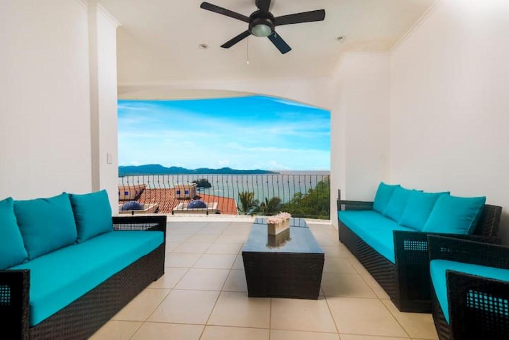 a living room with two couches and a ceiling fan at Playa Flamingo, Stunning Sunset View Condominium Flamingo Towers 17 in Playa Flamingo