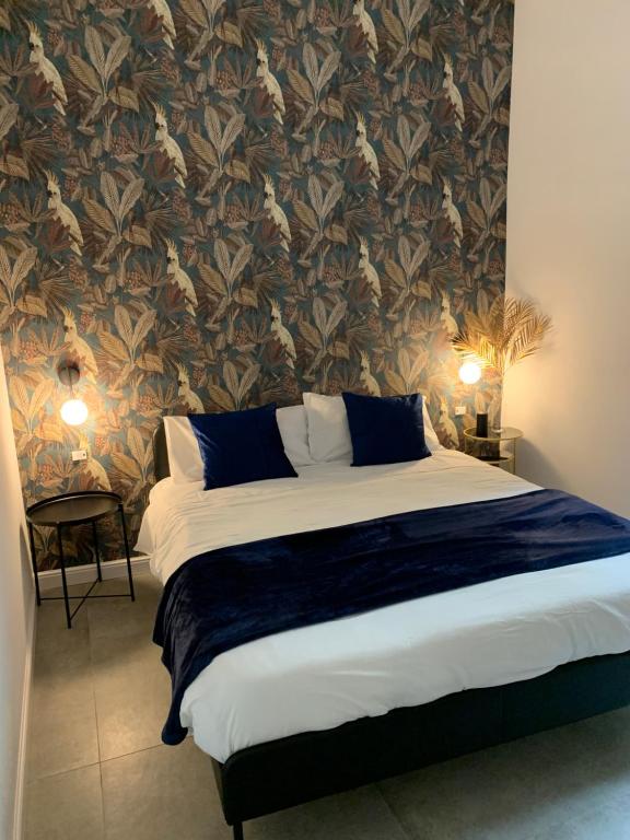 een slaapkamer met een groot bed en een muur met patronen bij Sellaria4 Guest House in Napels