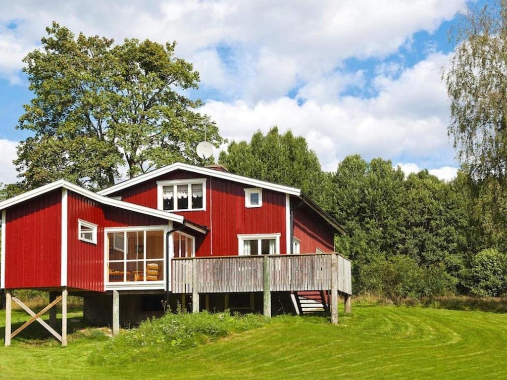 a red house sitting on top of a lush green field at 6 person holiday home in Br landa in Brålanda