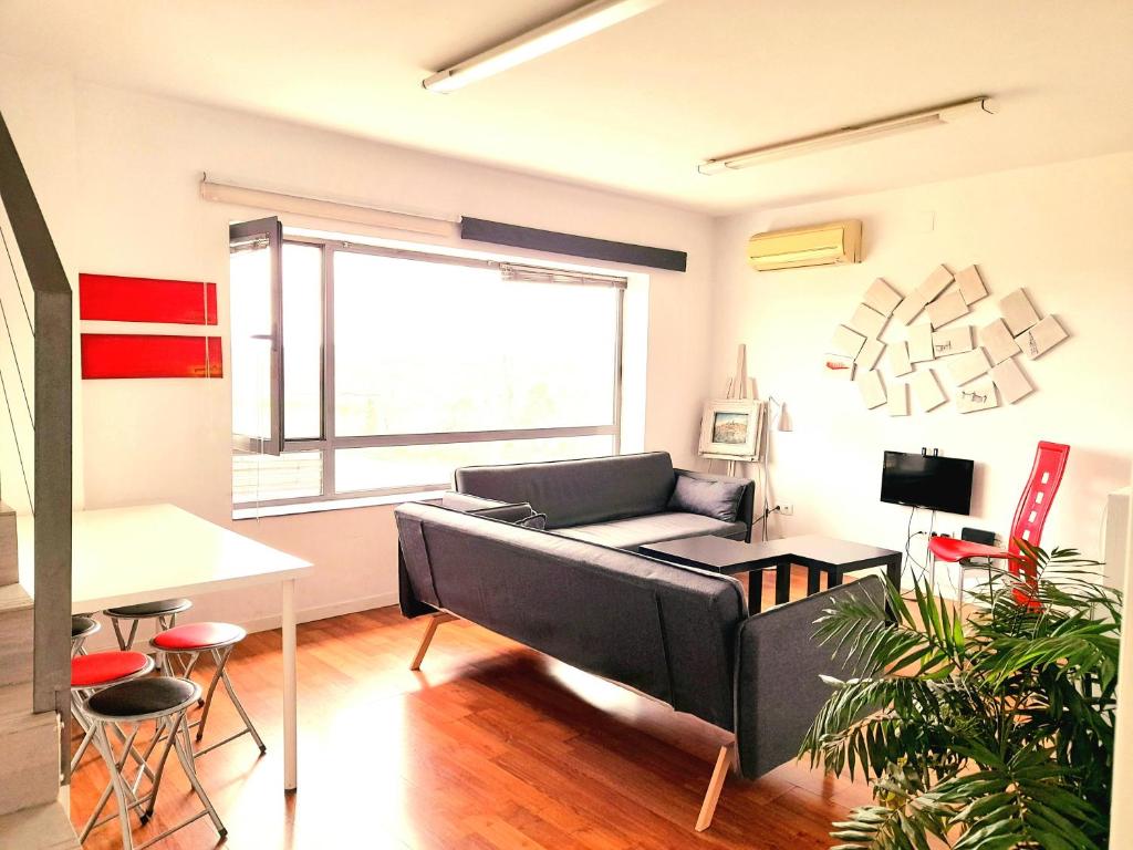 ein Wohnzimmer mit einem Sofa und einem Tisch in der Unterkunft TOLETUM low cost LOFTS diáfanos o 2dormitorios PARKING Municipal Gratis al aire libre a 100m in Toledo