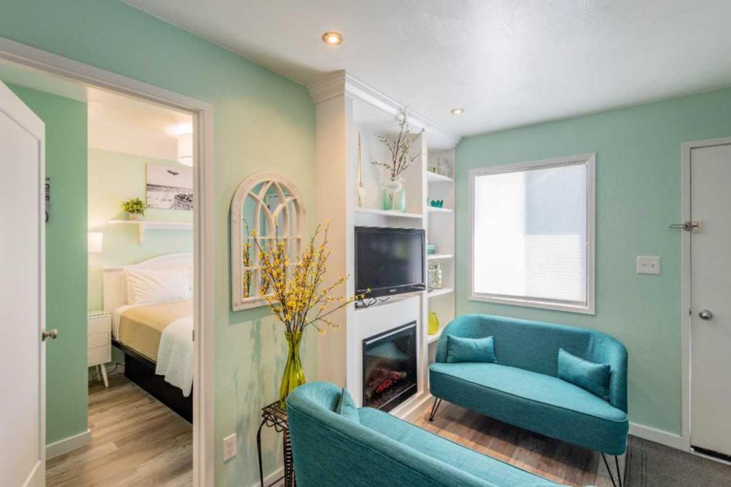 a living room with a blue couch and a bed at Beachside Inn in Seaside