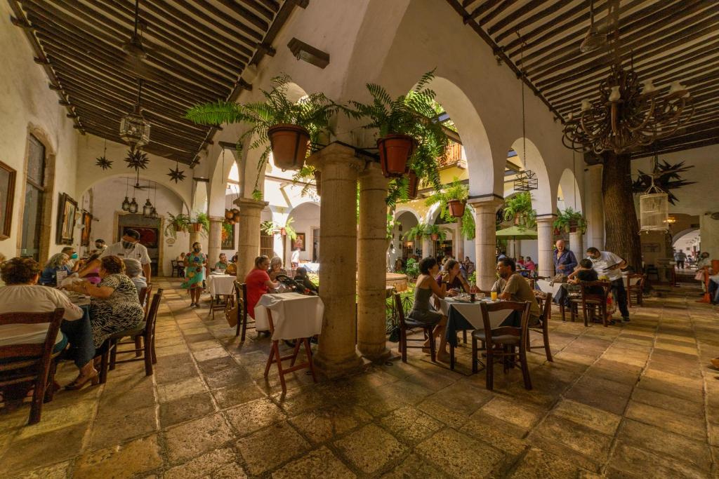 un grupo de personas sentadas en mesas en un restaurante en Hotel Meson del Marques, en Valladolid