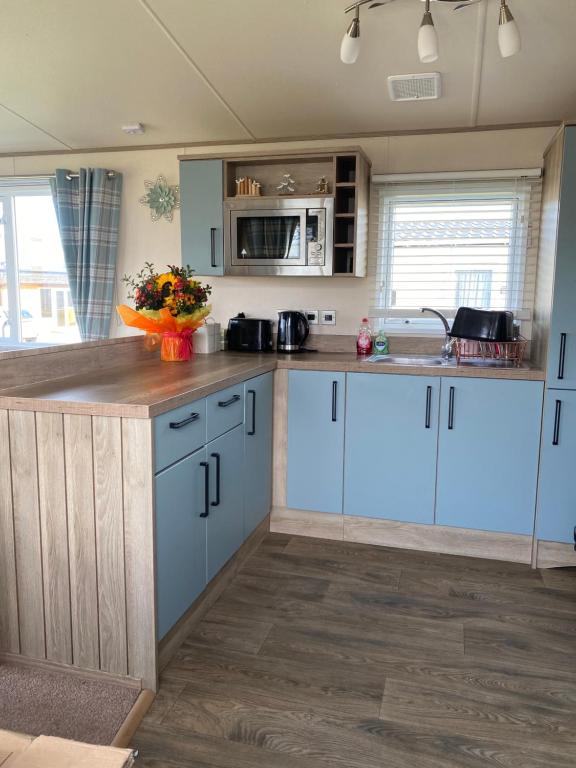 a kitchen with blue cabinets and a counter top at holidayhome-romneysands holiday park in Littlestone-on-Sea