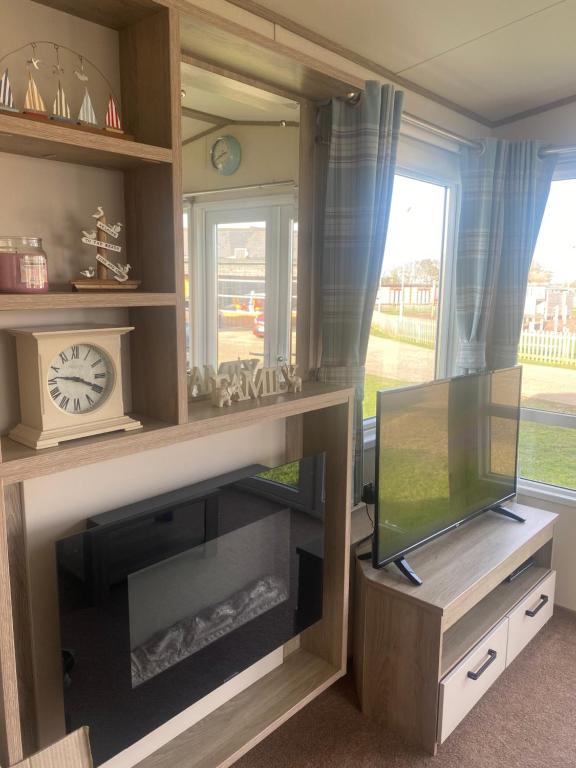 a living room with a tv and a window at holidayhome-romneysands holiday park in Littlestone-on-Sea