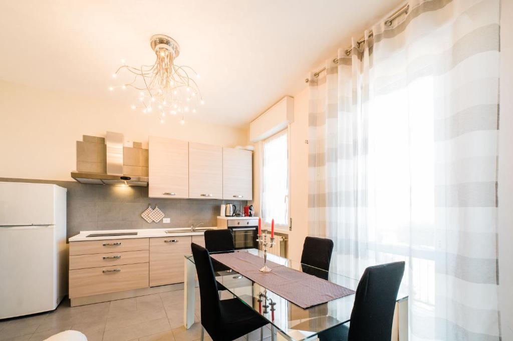 a kitchen with a table and chairs and a refrigerator at SLEEP & FLY Bergamo Centro in Bergamo