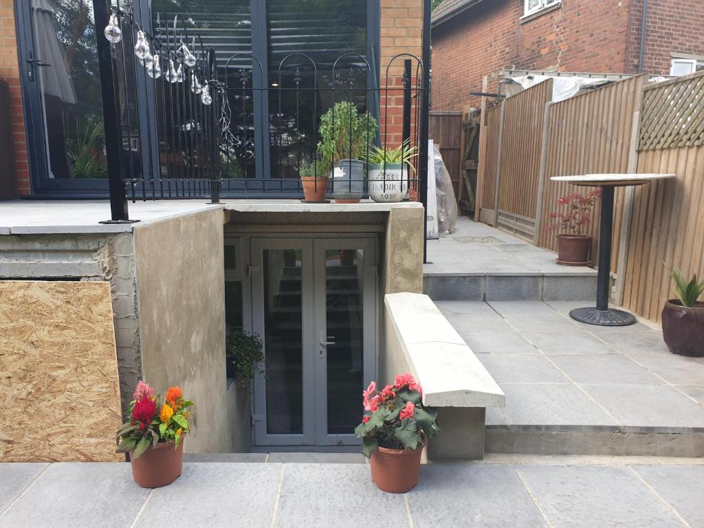 a building with a bench and some potted plants at Modern self contain studio Own Private Access in Finchley