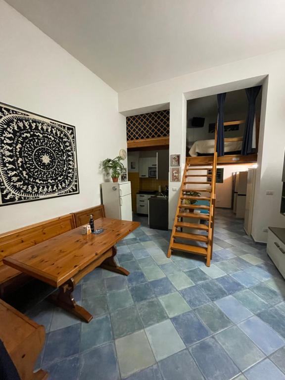 un soggiorno con tavolo in legno e letto a castello di Lime Apartments - LIDO ad Alghero