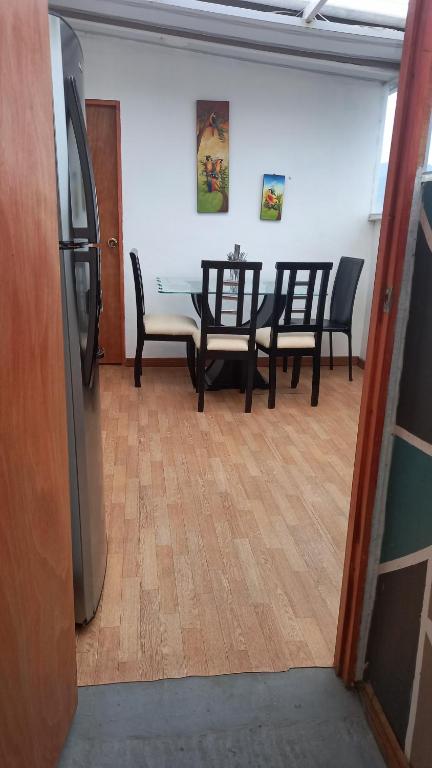 a dining room with a table and chairs and a refrigerator at Mi Balconcito in Salento