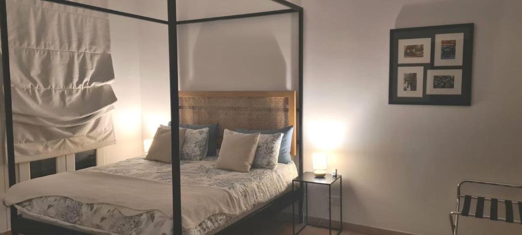 1 dormitorio con cama con dosel y almohadas en Cherrywood House, en Dubái