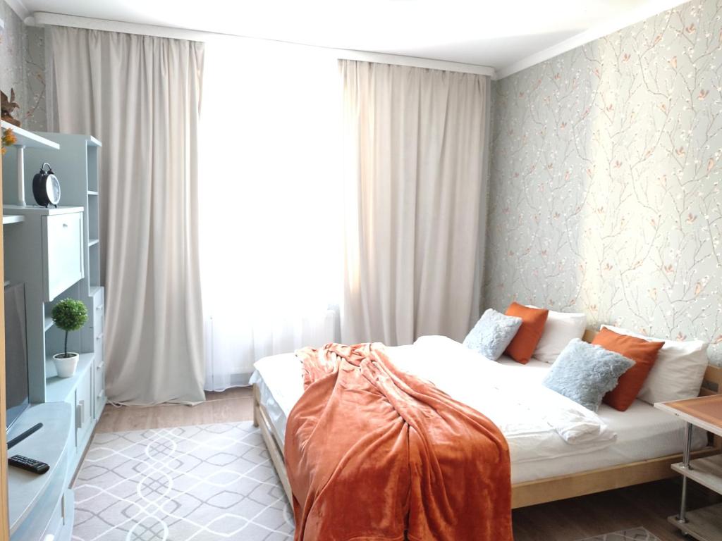 a bedroom with a bed and a large window at Уютное гнездышко у парка "Юность" in Kaliningrad