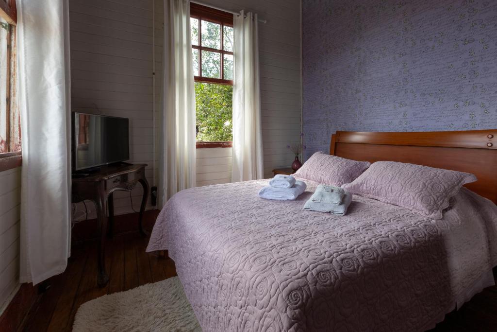 a bedroom with a bed with towels on it at Hospedaria Os Memorialistas - Paranapiacaba in Paranapiacaba