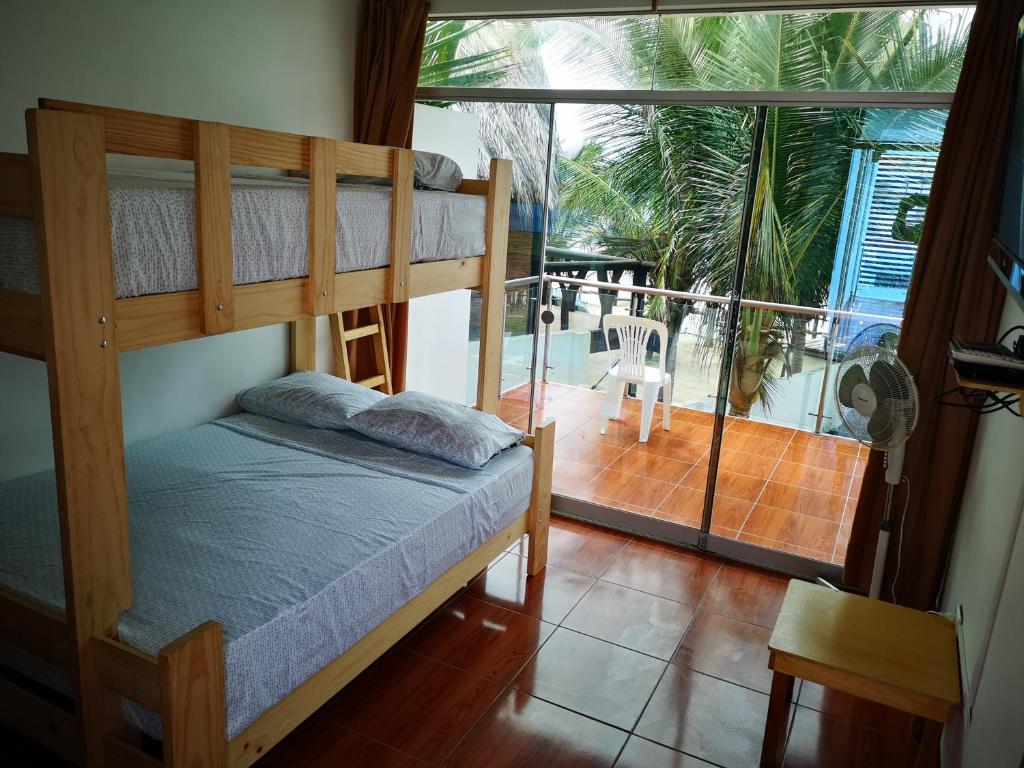 a bedroom with two bunk beds and a balcony at Casa de Mateo - Zorritos - Tumbes in Zorritos