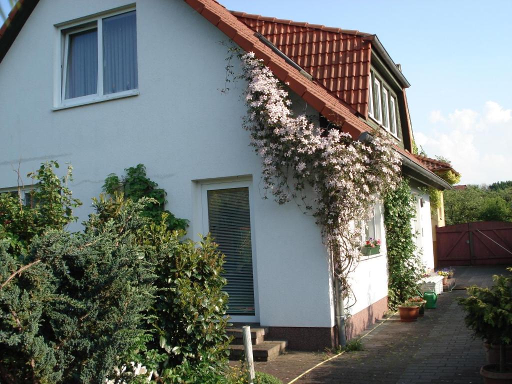 Una casa blanca con flores a un lado. en Vermietung Wenzel, en Stralsund