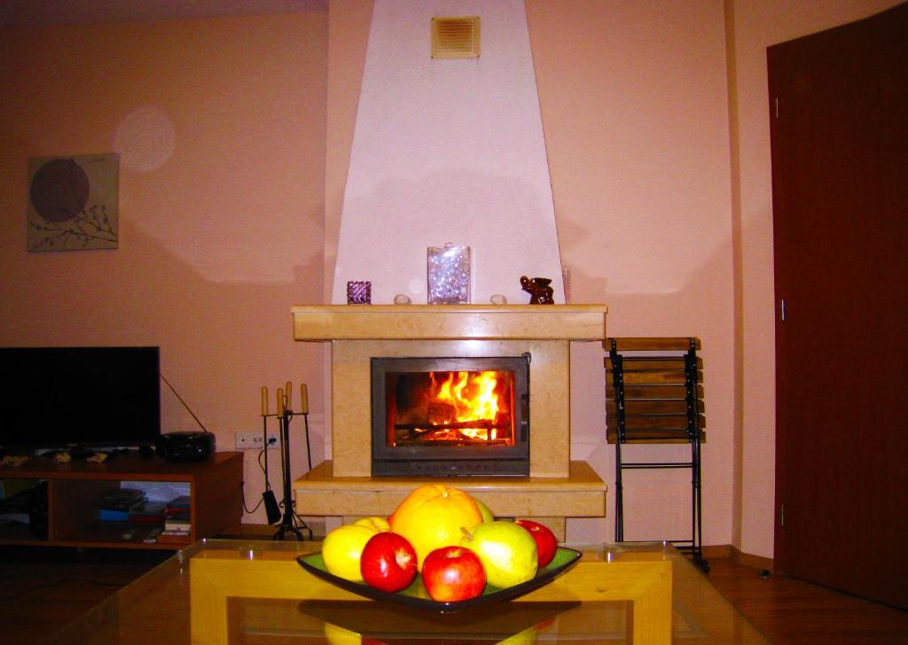 a bowl of fruit on a table in front of a fireplace at Solar nest with fireplace and panoramic view 700m from skilift and centrum in Bansko