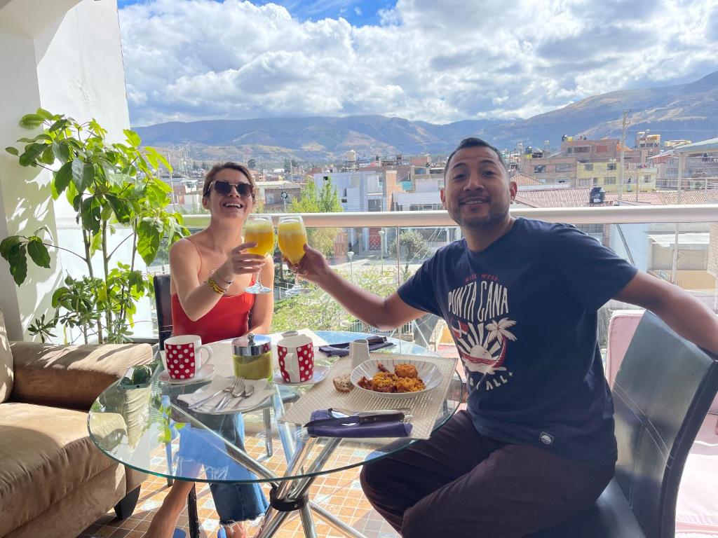 a man and a woman sitting at a table with drinks at CasaHotel El Tambo Huancayo in Huancayo