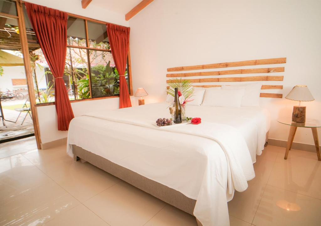 Un dormitorio con una gran cama blanca con flores. en Country Club Eco Casajardin, en Moyobamba