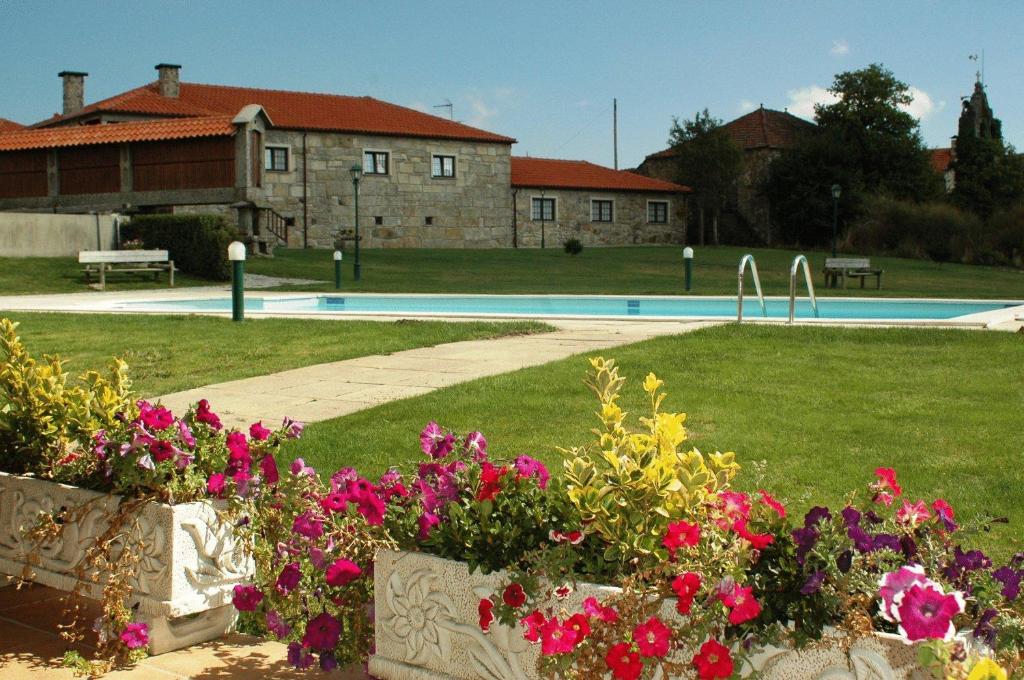 a yard with flowers and a swimming pool at Casa Da Eira Longa in Vilar