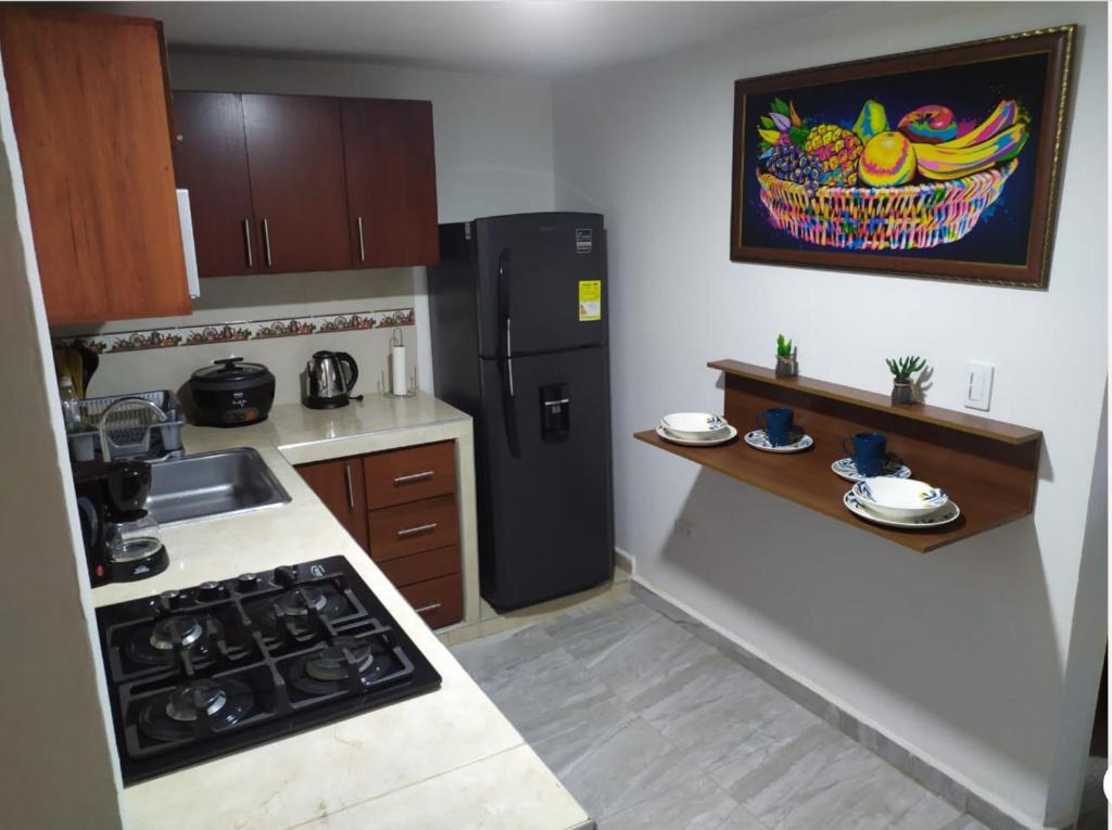 una piccola cucina con frigorifero nero e bancone di Piso 2-apartment near to Cali Airport a Palmira
