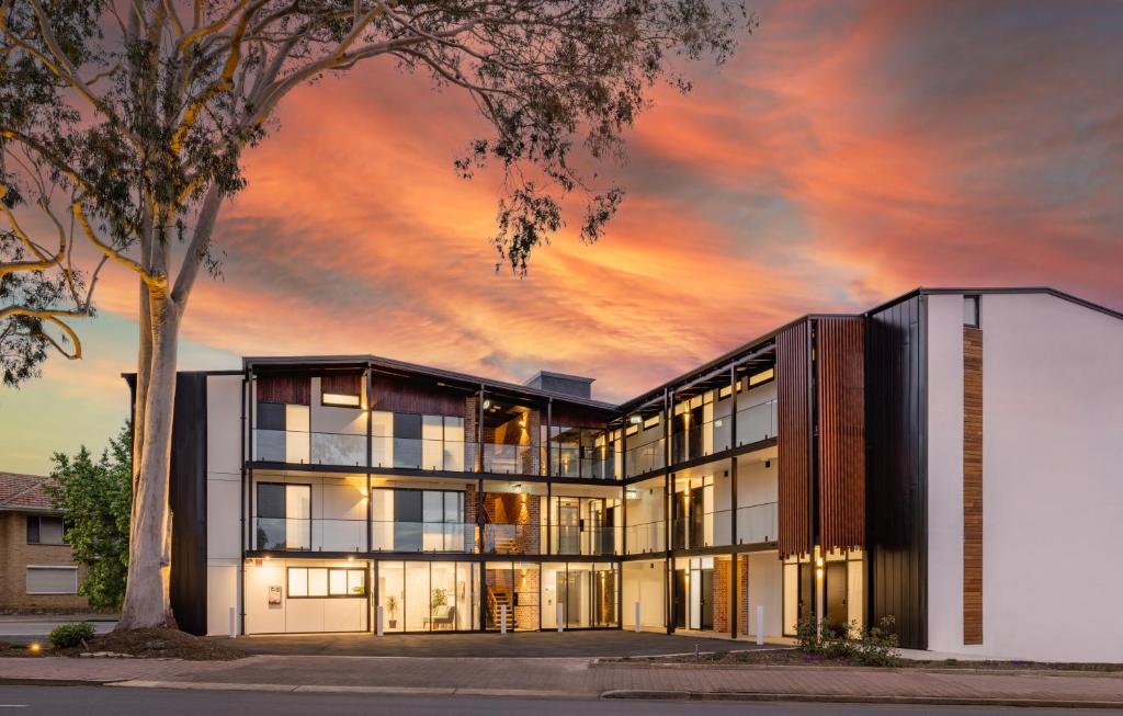 um edifício de escritórios com um pôr-do-sol ao fundo em The Osmond Motel & Apartments em Adelaide