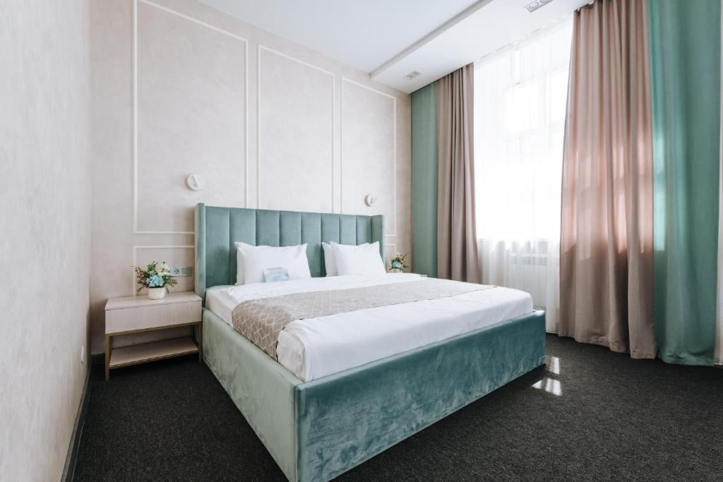 a bedroom with a bed and a large window at Panorama Hotel in Izhevsk