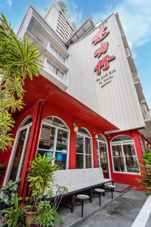 a red building with a bench in front of it at Talakkia Boutique Hotel in Bangkok