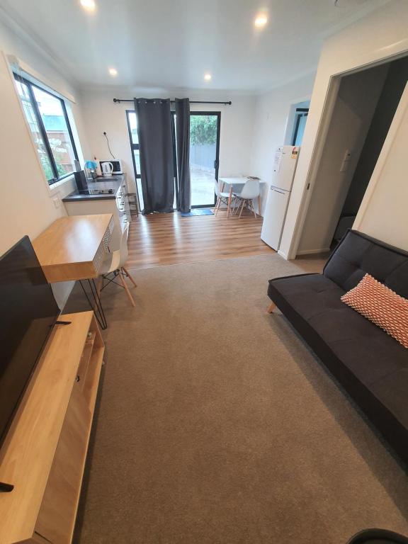a living room with a couch and a table at Modern 1 bedroom guest house in Upper Hutt