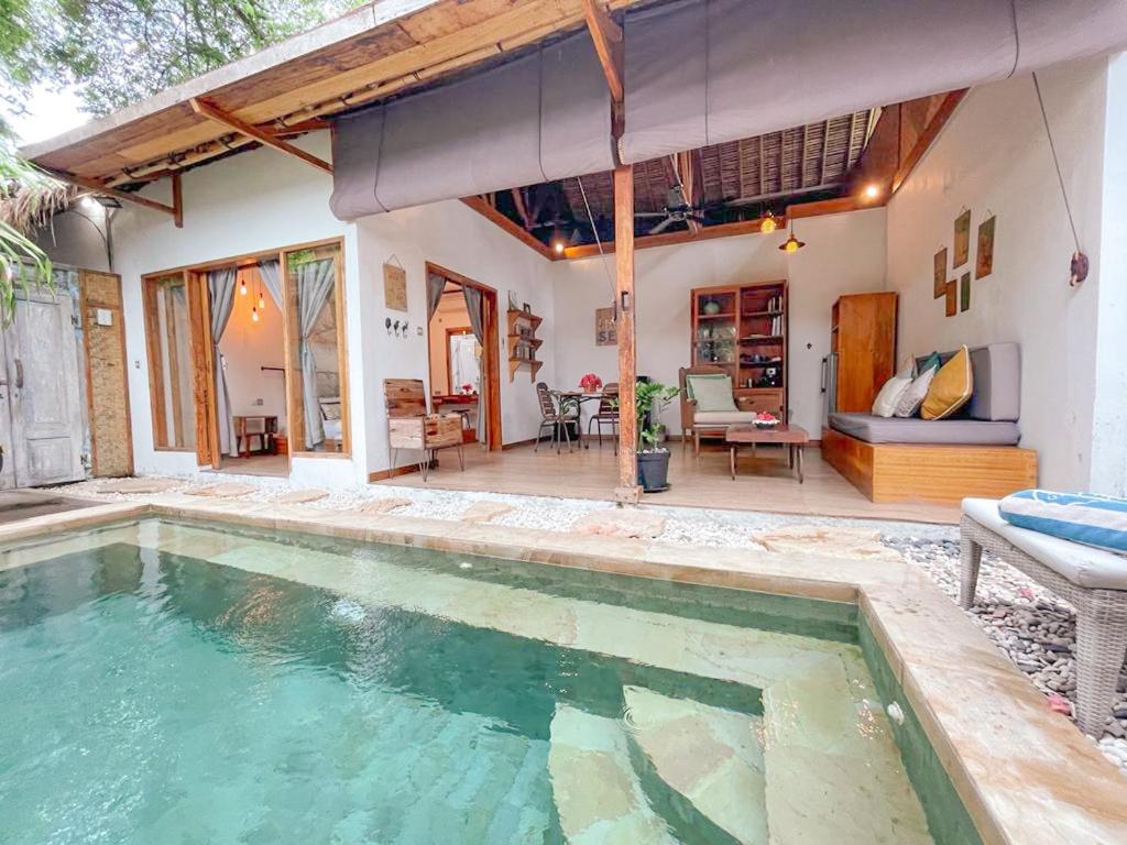 a house with a swimming pool and a patio at Villa Casa Koko in Gili Air