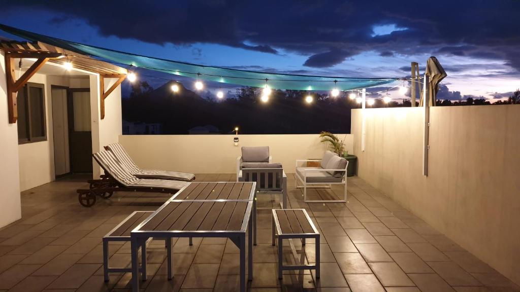 a rooftop patio with tables and chairs at night at Westwood Luxury Penthouse with private Roof top Ref 15847 in Flic-en-Flac